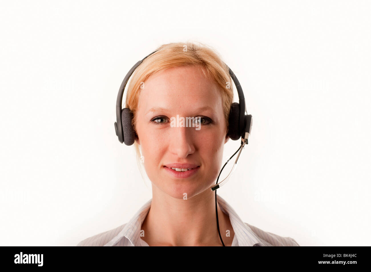 Blonde female Customer Services Telesales person wearing a telephone headset smiling FULLY MODEL RELEASED Stock Photo