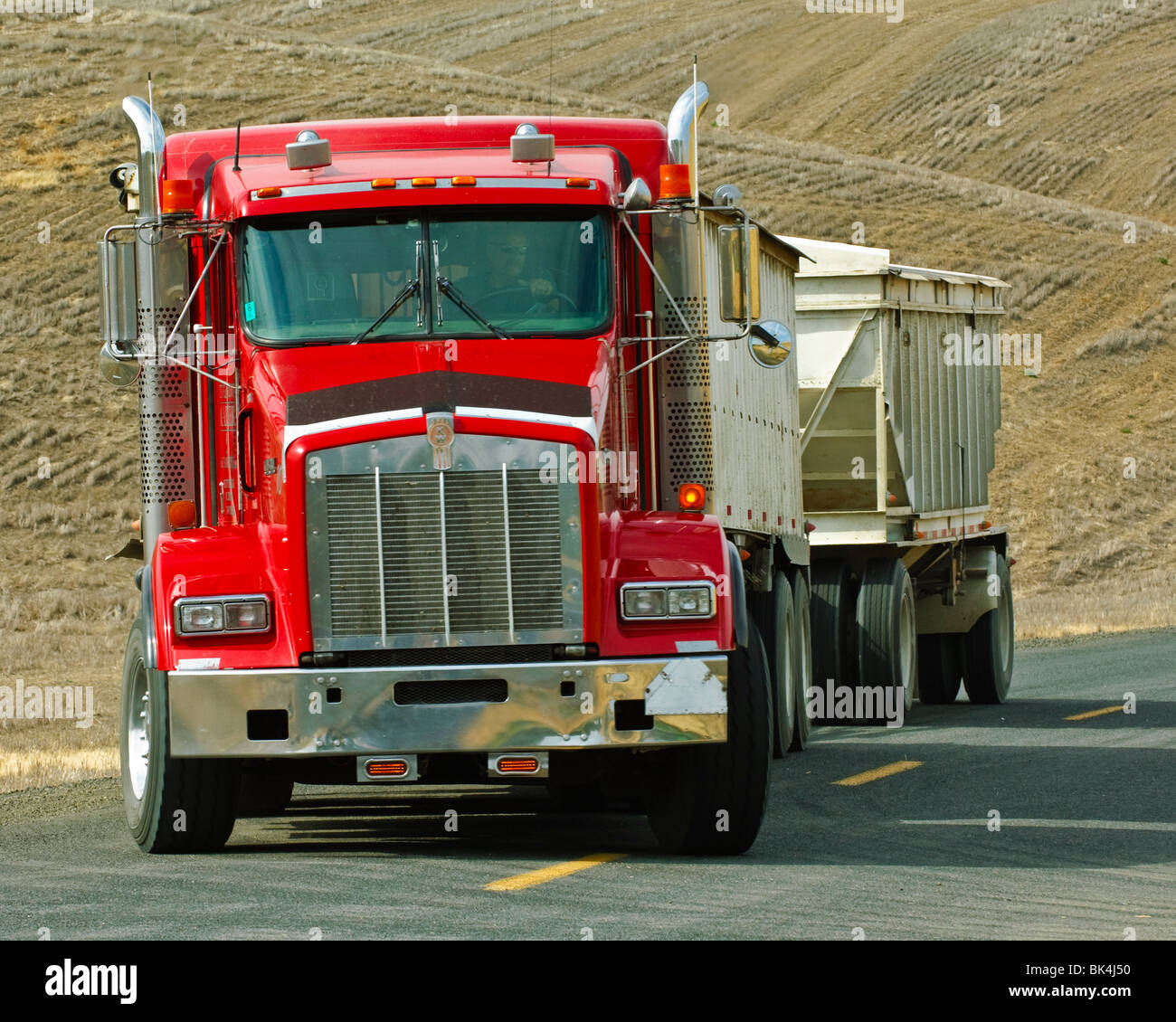A grain truck turns into a wheat field to get another load of grain to haul in Eastern Washington Stock Photo