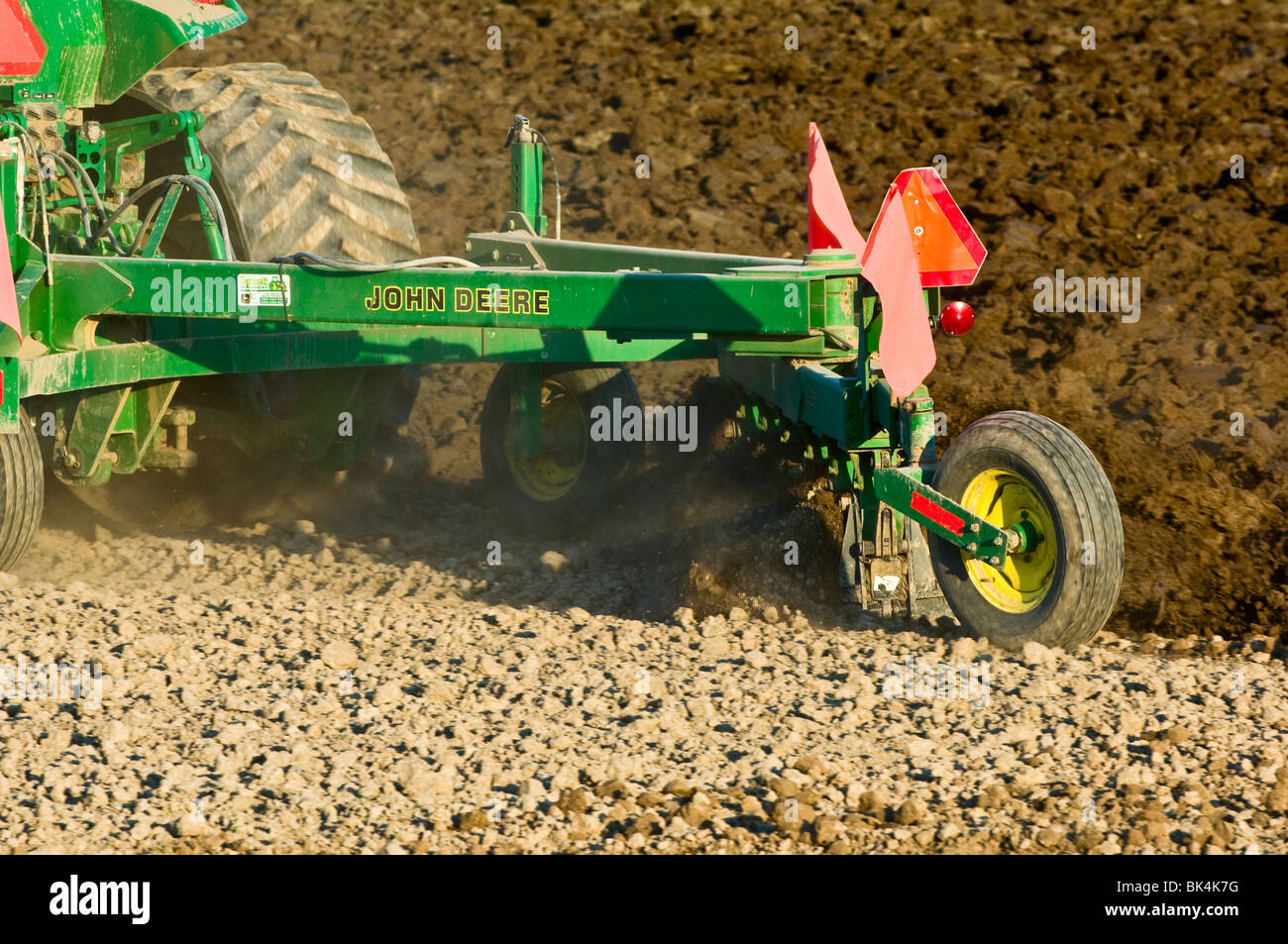 John Deere tractor plowing with reversible plow to prepare the field