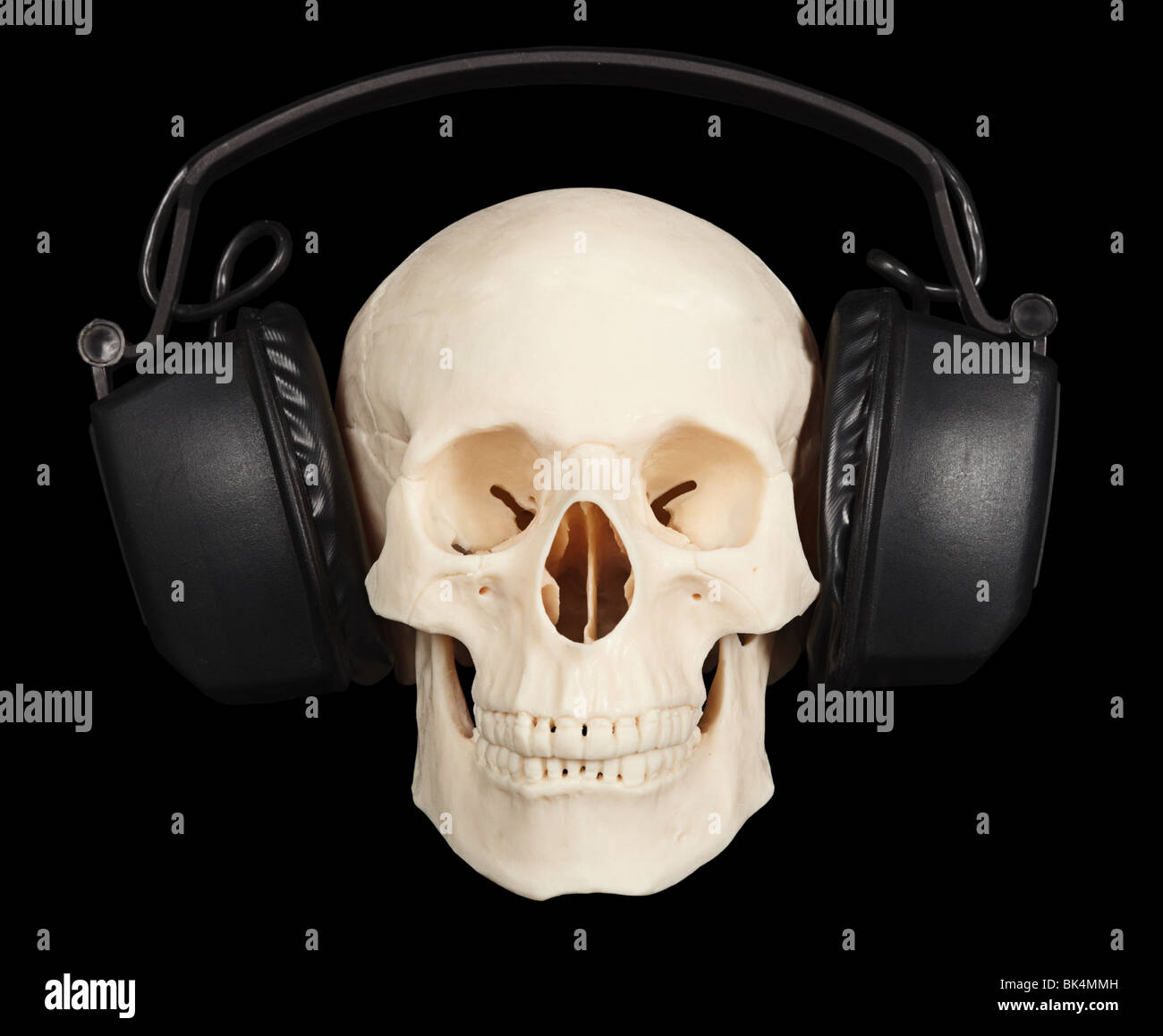 The human skull with stereo headphones on a black background Stock Photo