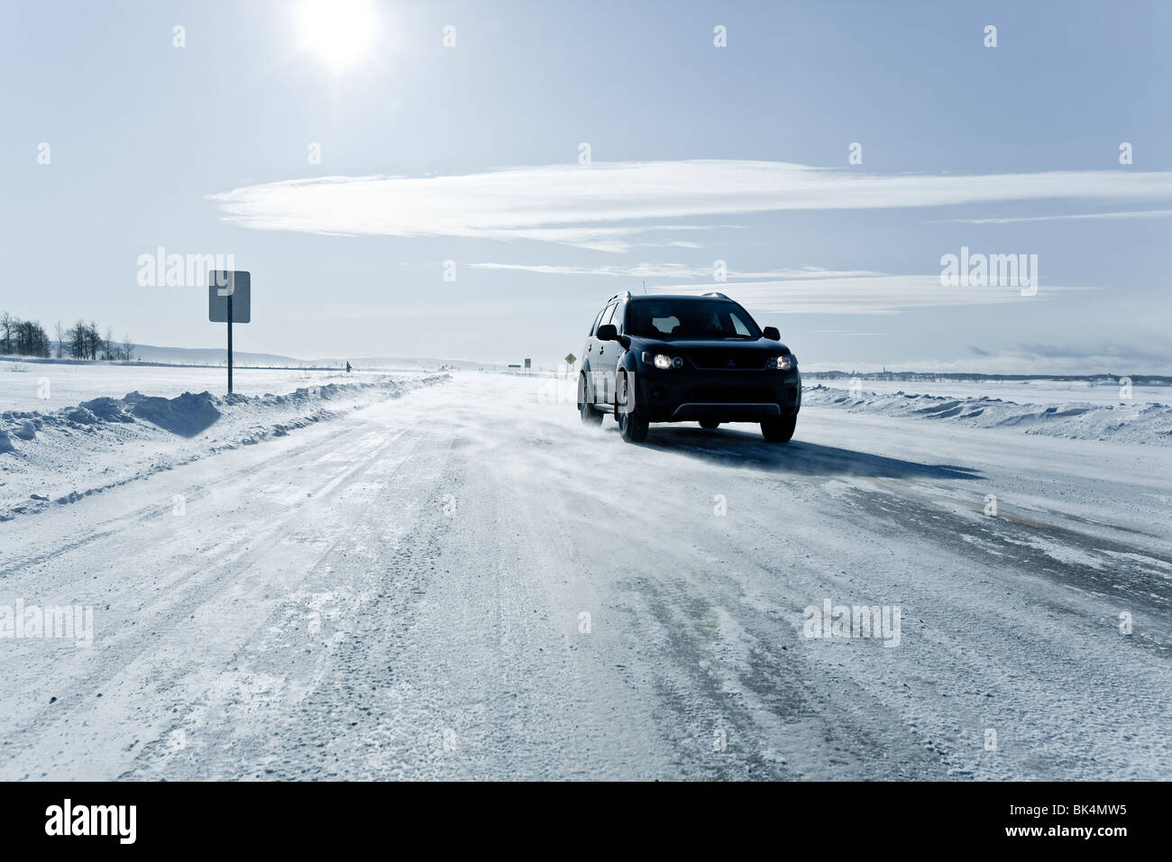 SUV on a country road with snow blowing. Stock Photo