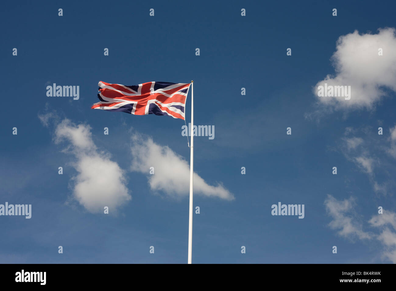 The Union Jack flag flies in a stiff breeze against cirrus clouds and ...