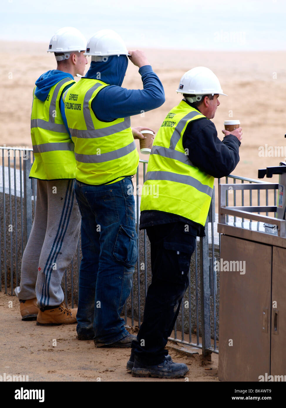 Three workmen having a coffee, Watergate Bay, Cornwall Stock Photo