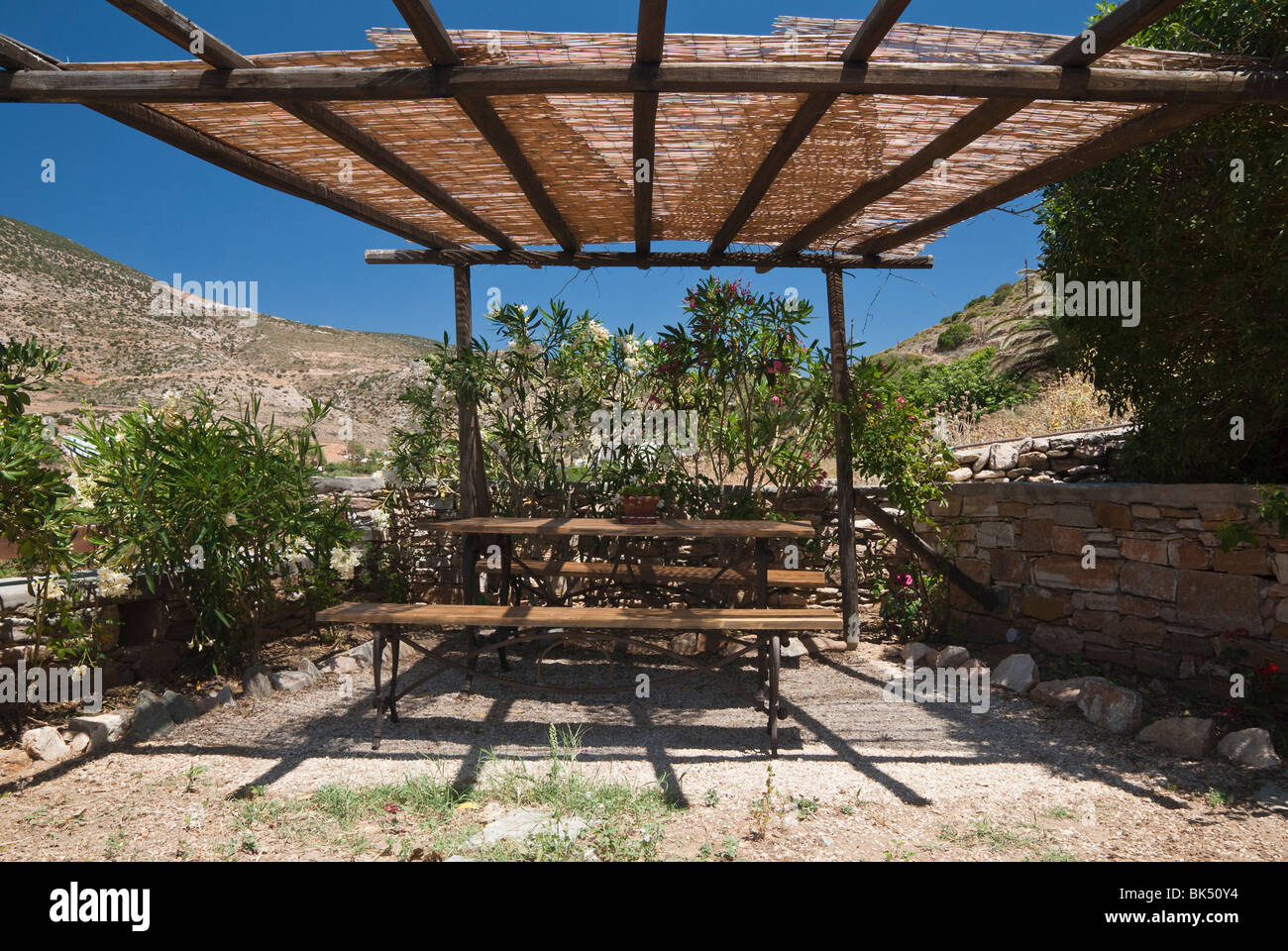 Shaded outdoor table and chairs in Greece Stock Photo