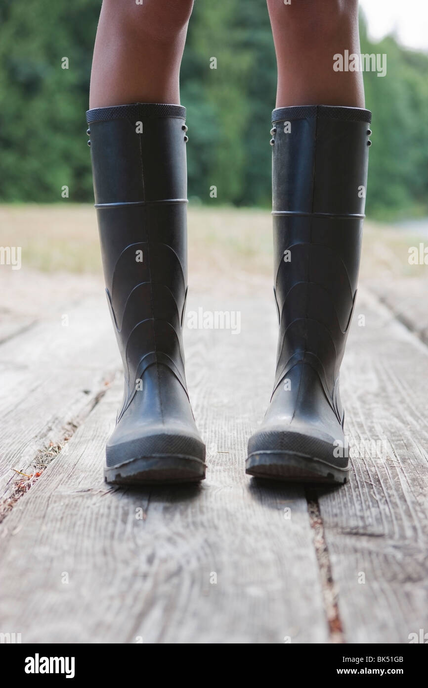 Close-up of Woman Wearing Rubber Boots on Dock, Near Portland, Oregon, USA Stock Photo