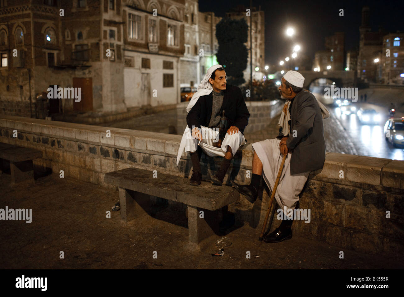 Two men talk and enjoy an evening in the Old City of Sana'a, Yemen Stock Photo