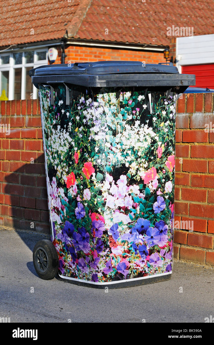 Hand decorated domestic rubbish 'wheelie bin' waiting outside house for