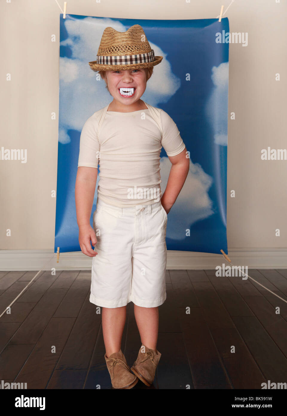 Boy with hat and fangs infront of sky background Stock Photo