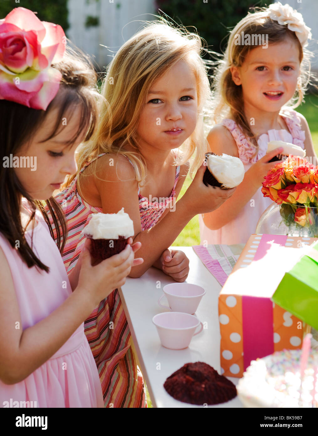 Young girls eating cupcakes at a birthday party Stock Photo