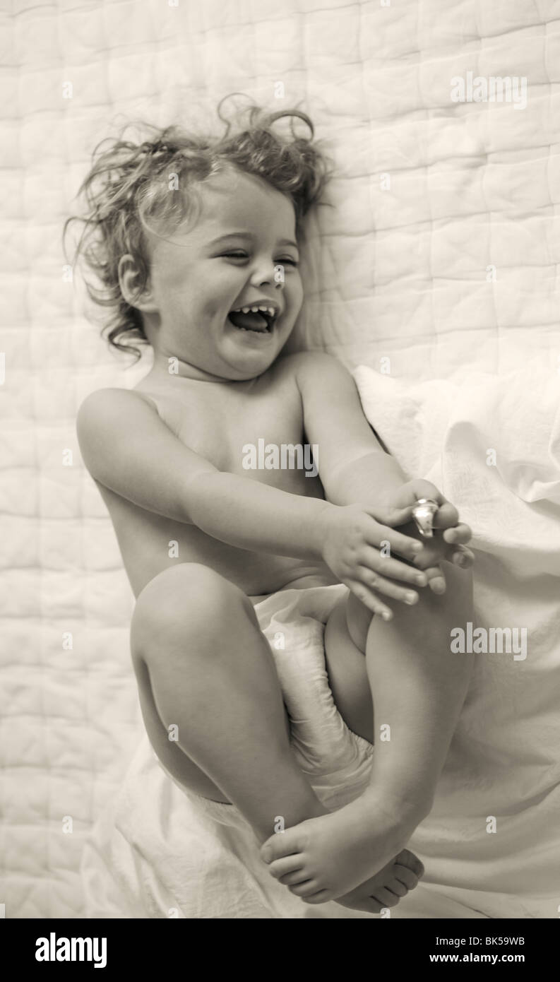 Happy toddler laying on bed Stock Photo