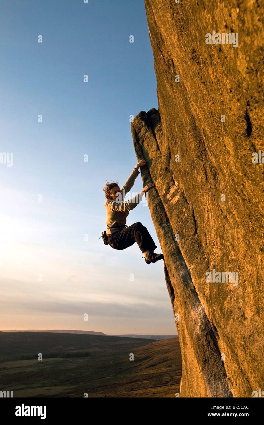 A climber on a popular gritstone bouldering route on the Plantation
