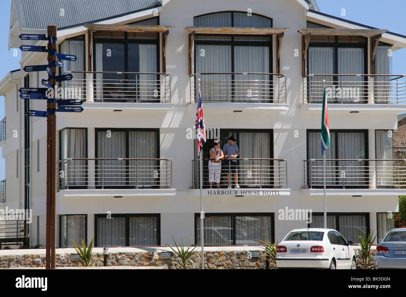 Hotel rooms balconies guests and parking at the Harbour House Hotel in Hermanus a popular seaside resort S Africa Stock Photo