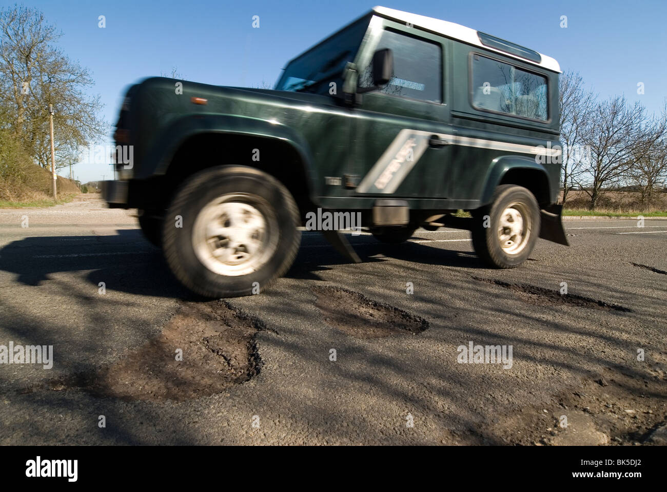 potholes in the middle of the road after a hard winter of snow. Who will pay for these pot holes to be repaired? Stock Photo