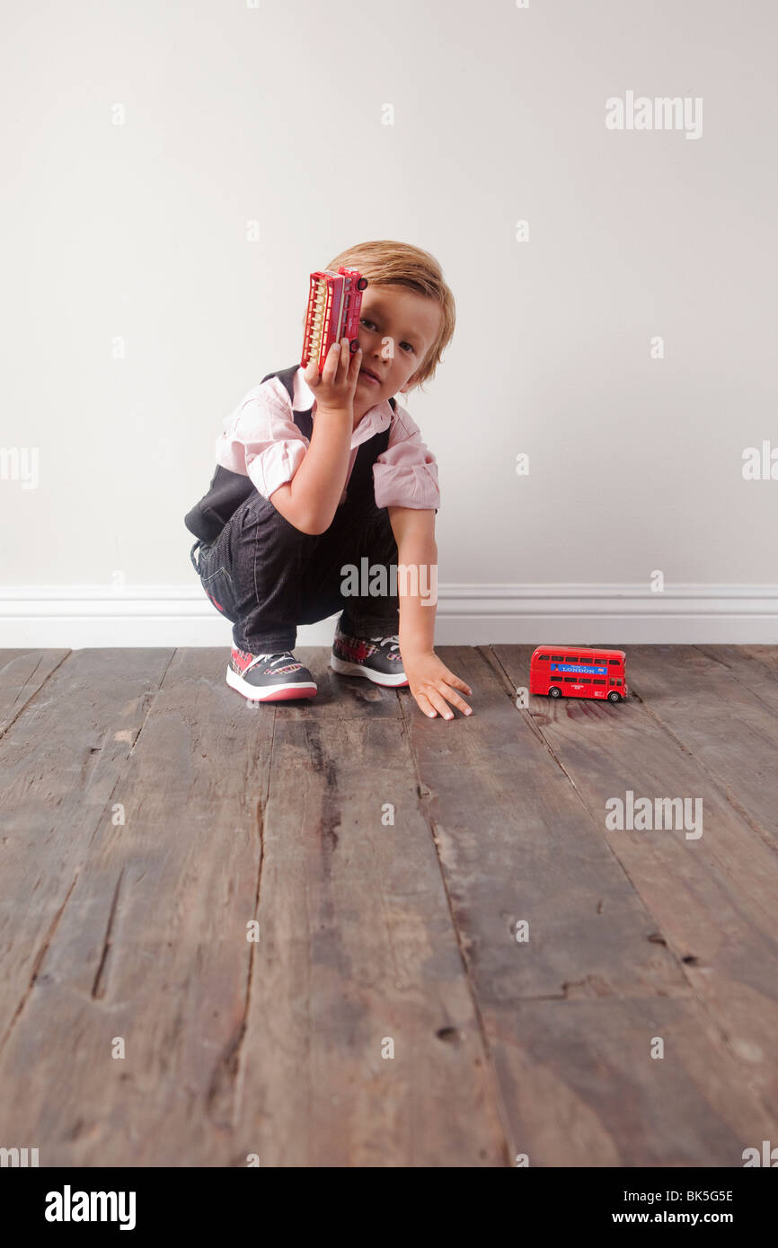 Young boy playing with toy cars Stock Photo - Alamy