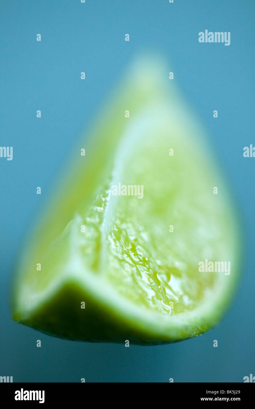 A fresh slice of lime with selective focus on a clean glass surface with copyspace Stock Photo