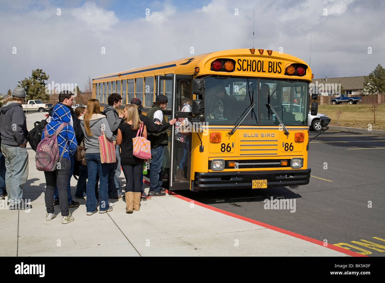 High school students board a school bus for the afternoon trip home Stock Photo