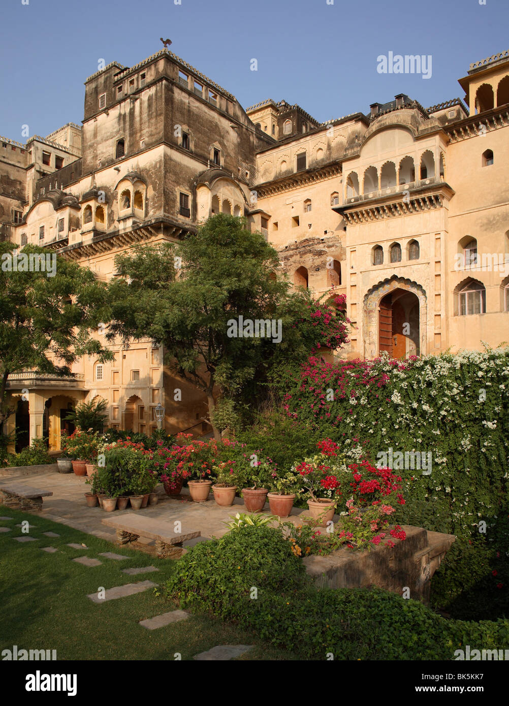 The exterior of the Neemrana Fort Palace painted in ochre tones and sporting a profusion of jarokhas, Neemrana, Rajasthan, India Stock Photo