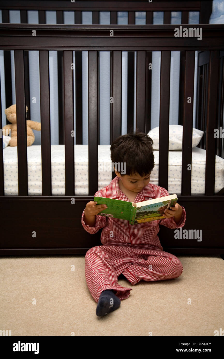 Three year old boy reading a book before bedtime Stock Photo