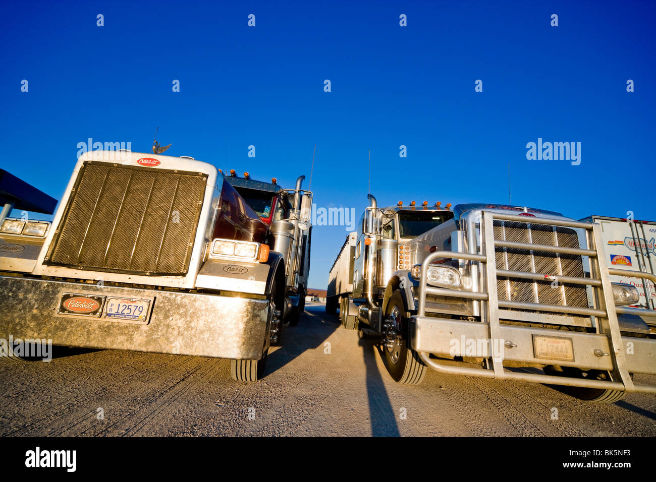 Two American Peterbilt trucks at a truck stop in the Mid West against a blue sky Stock Photo