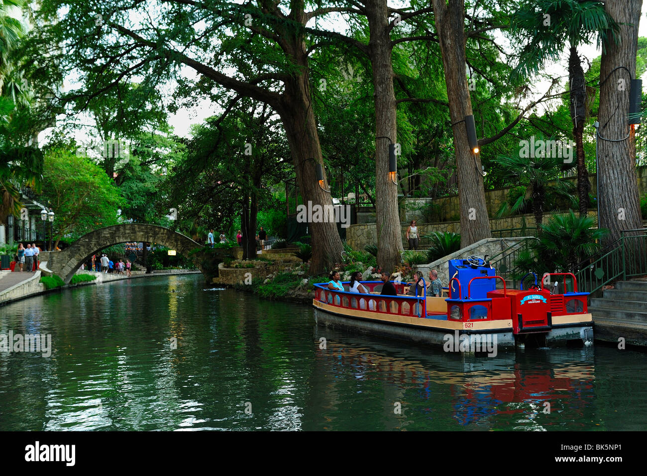 Boat guiding tourists through the riverwalk in San Antonio, Texas. Stock Photo