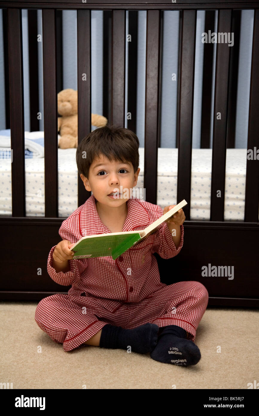Three year old boy reading a book before bedtime Stock Photo