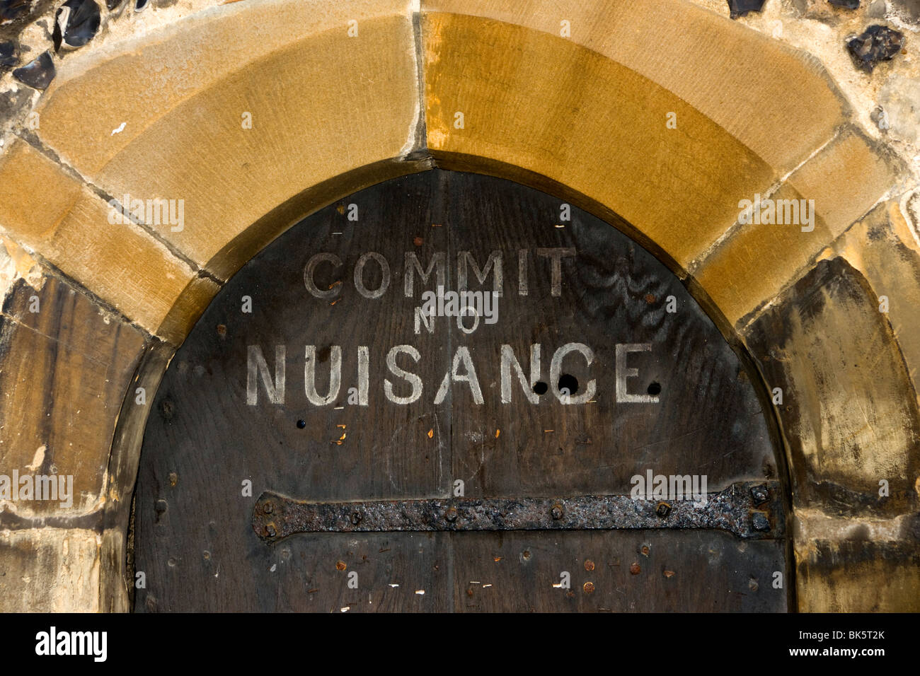 Commit No Nuisance sign on ancient door, St. Albans, UK Stock Photo