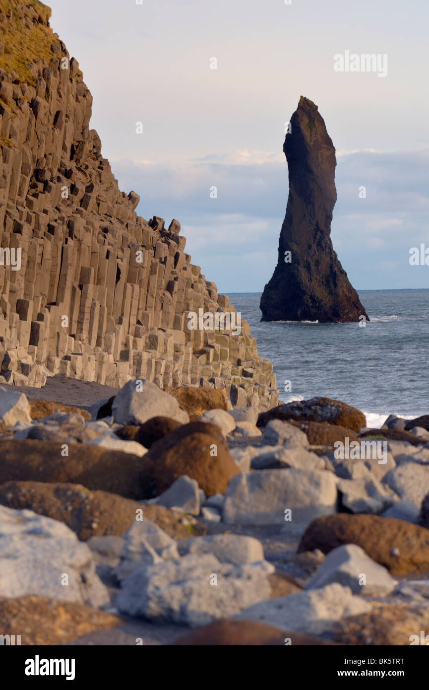 Columnar basalt cliffs and Reynisdrangar sea stack standing in the sea, near Vik, South Iceland, Iceland, Polar Regions Stock Photo