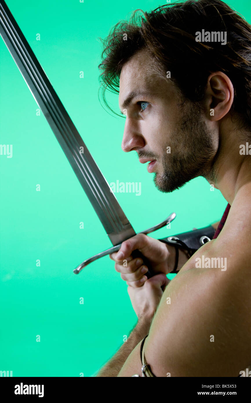 Young man in warrior costume holding a sword Stock Photo
