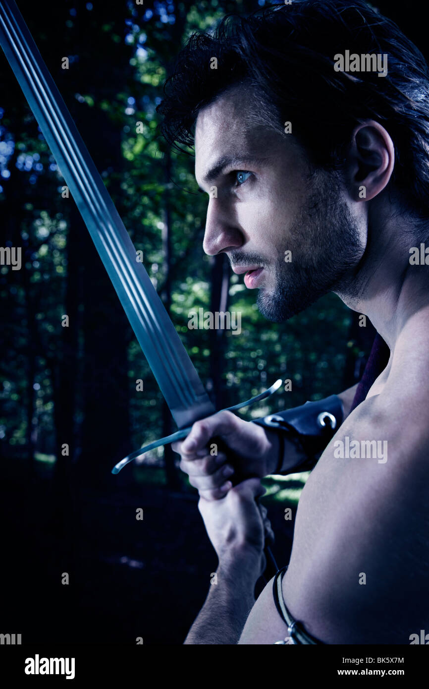 Young man in warrior costume holding a sword Stock Photo