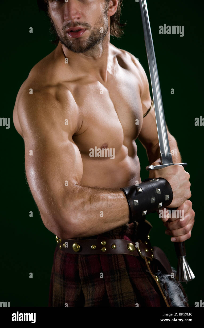 Young man in warrior costume holding a sword Stock Photo - Alamy