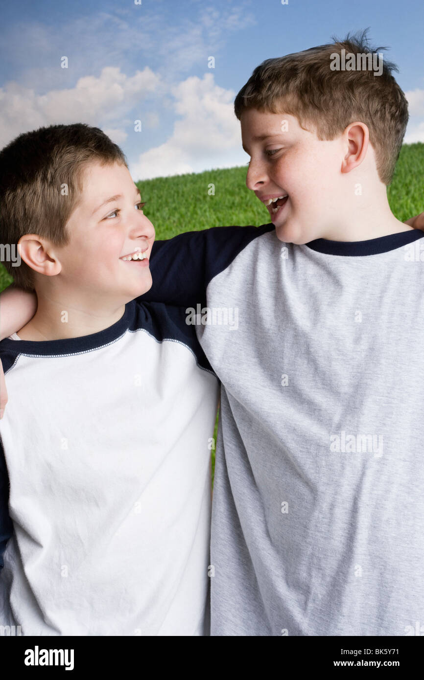 Two boys standing with arm around each other Stock Photo - Alamy