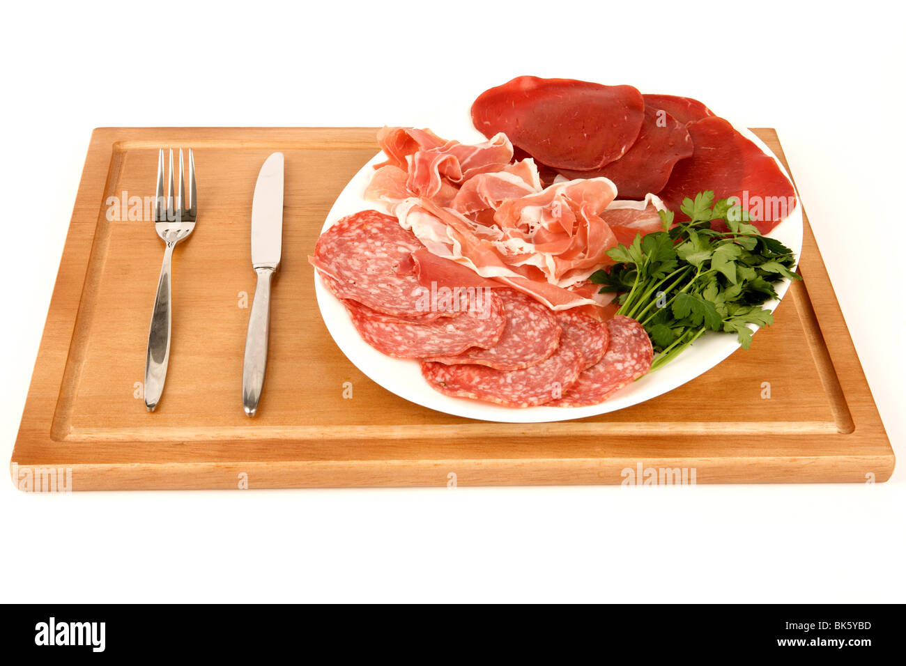 A plate of Italian meats with Salami and bresaola on a wooden chopping board Stock Photo