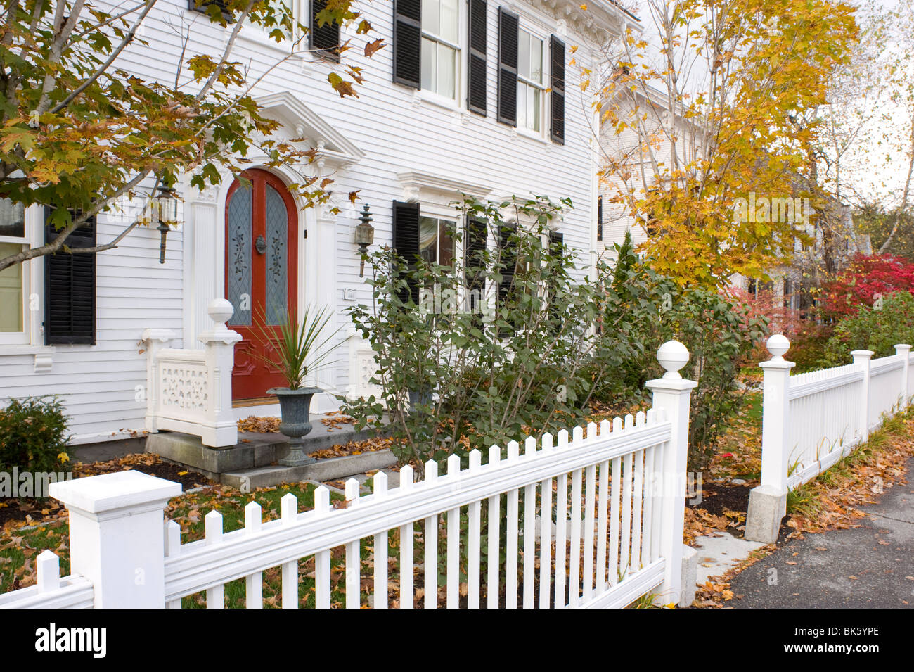 A traditional wood house and picket fence surrounded by autumn leaves in Woodstock, Vermont, USA Stock Photo