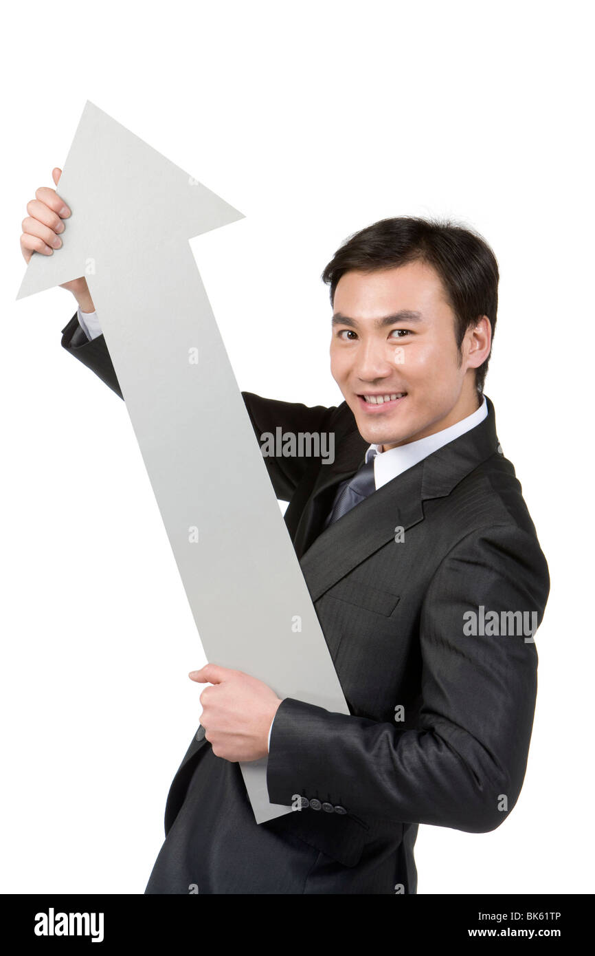 Young businessman holding arrow Stock Photo - Alamy