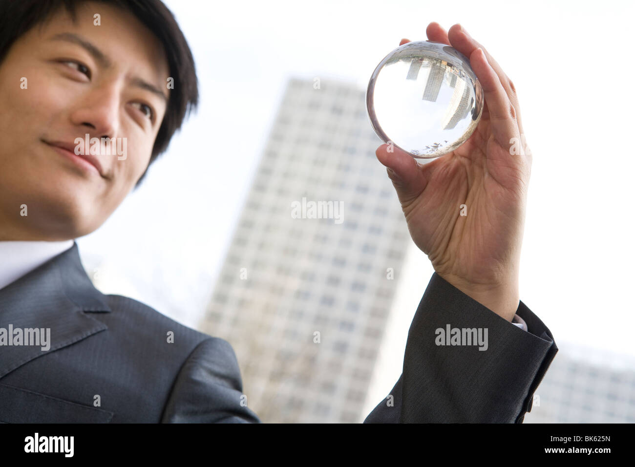 Businessman holding crystal ball Stock Photo - Alamy