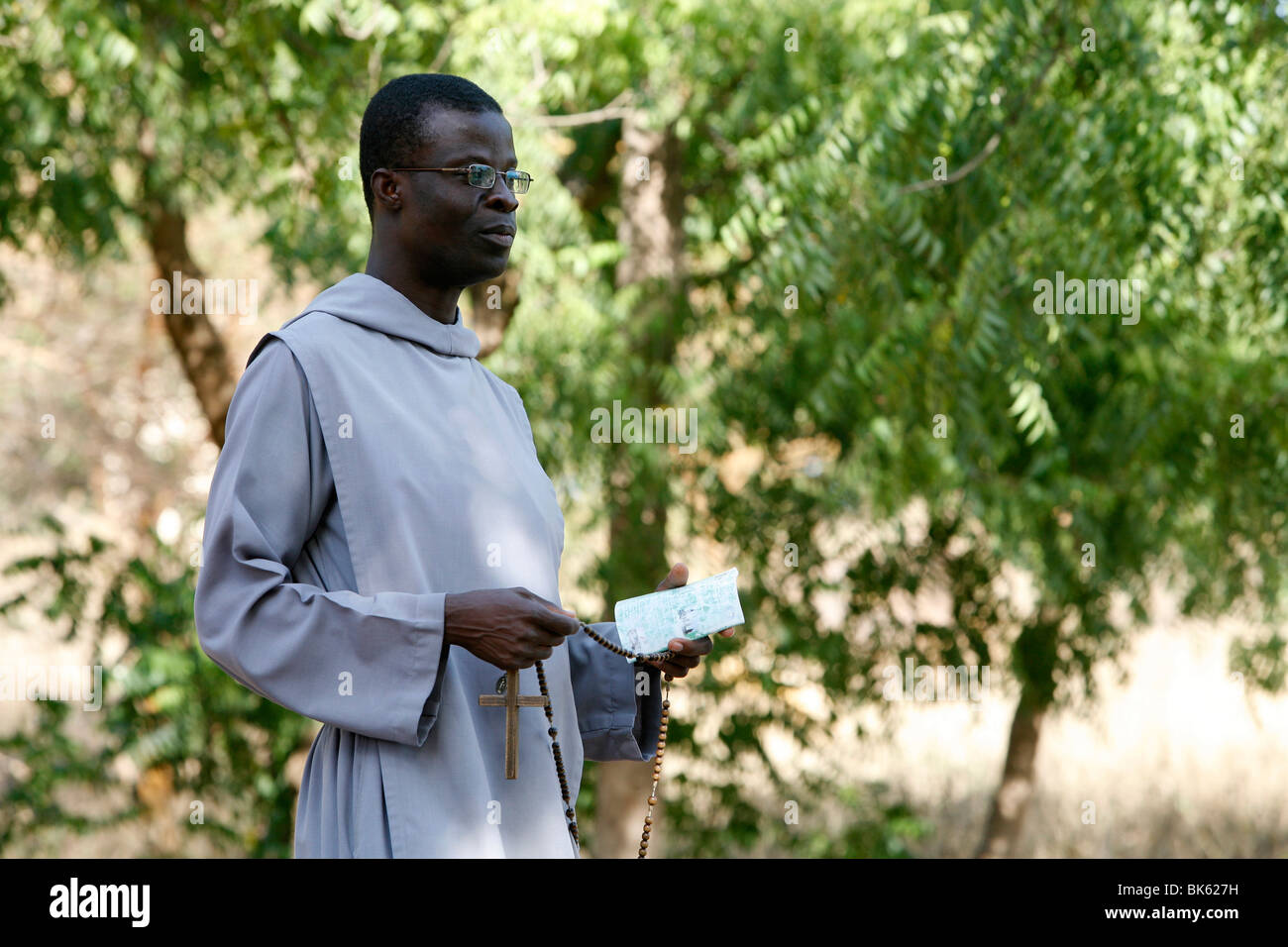 Catholic friar holding rosary and prayer book, Popenguine, Thies, Senegal, West Africa, Africa Stock Photo