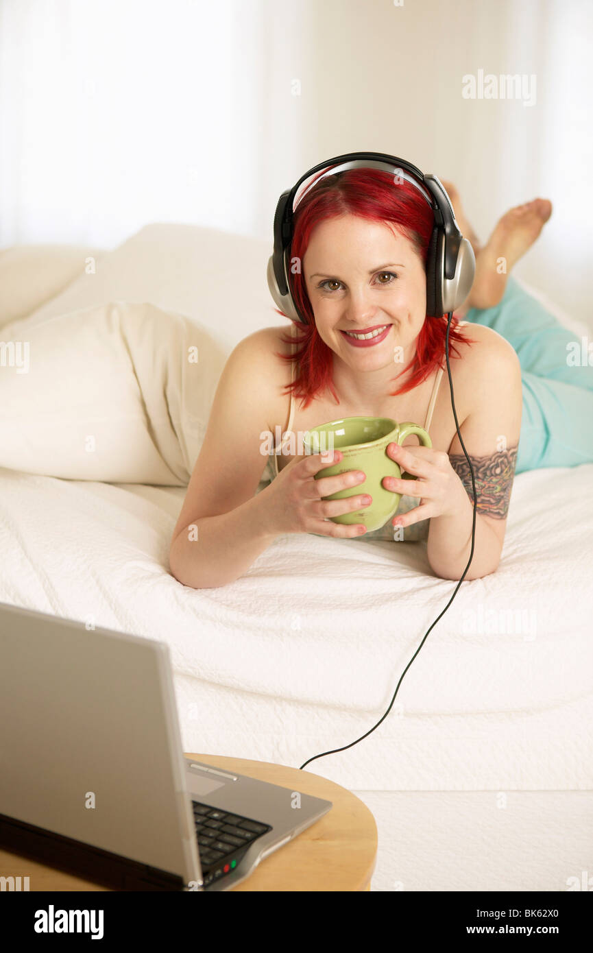 Teenage girl lying on the bed and listening to music Stock Photo - Alamy