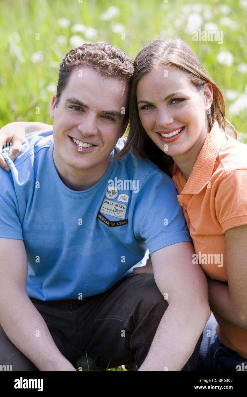 Young couple look at camera in meadow land Stock Photo