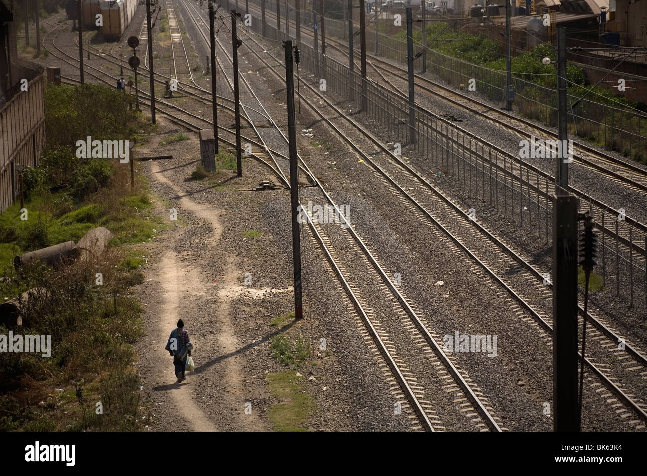 An undocumented Central American migrant traveling across Mexico to United States walks along the railroad tracks in Mexico City Stock Photo