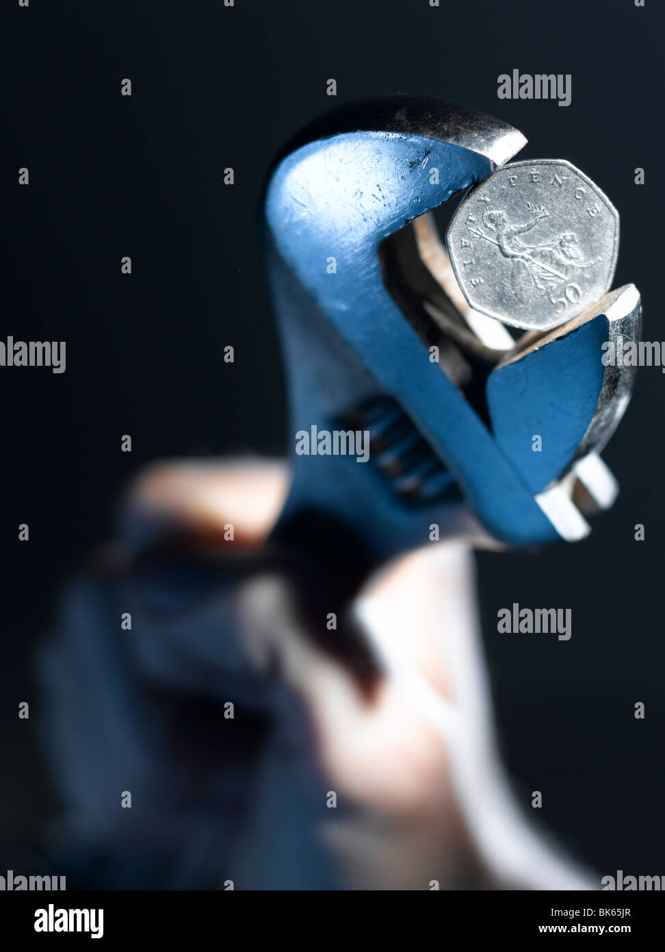 Wrench gripping 50 pence piece Stock Photo Alamy