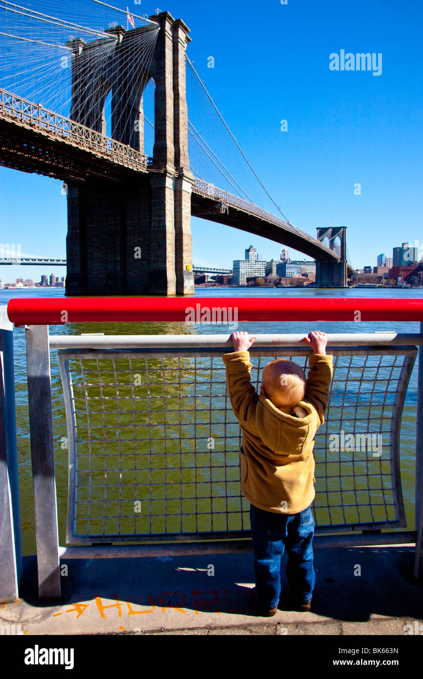 Young boy in front of the Brooklyn Bridge in Manhattan, New York Stock Photo