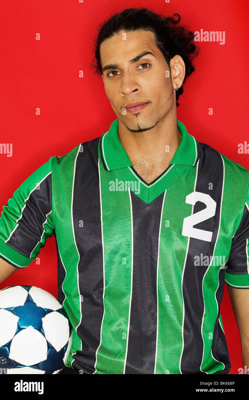 Portrait of a young man holding a soccer ball Stock Photo - Alamy