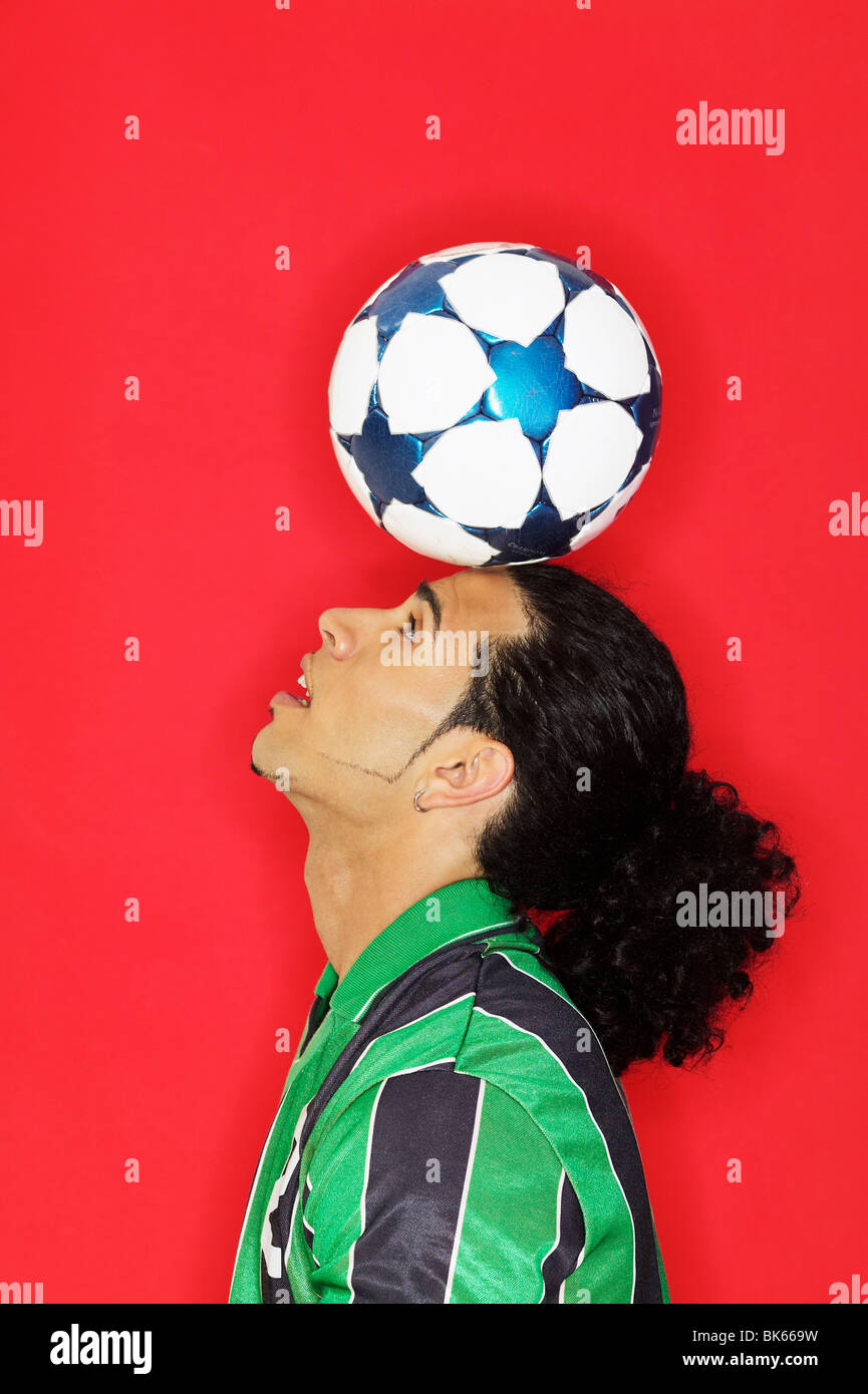 Young man balancing a soccer ball on his head Stock Photo Alamy