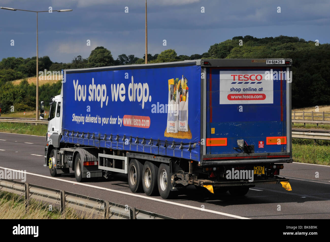 Side view hgv supermarket food supply chain store grocery delivery lorry truck with trailer advertising Tesco food business driving on UK motorway Stock Photo