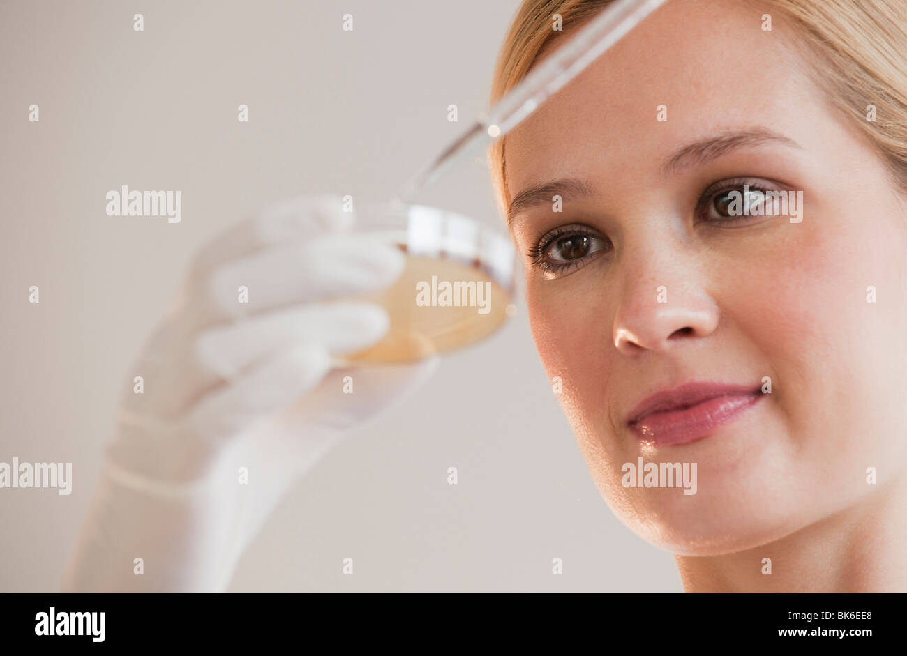 female scientist with dropper and petri dish Stock Photo