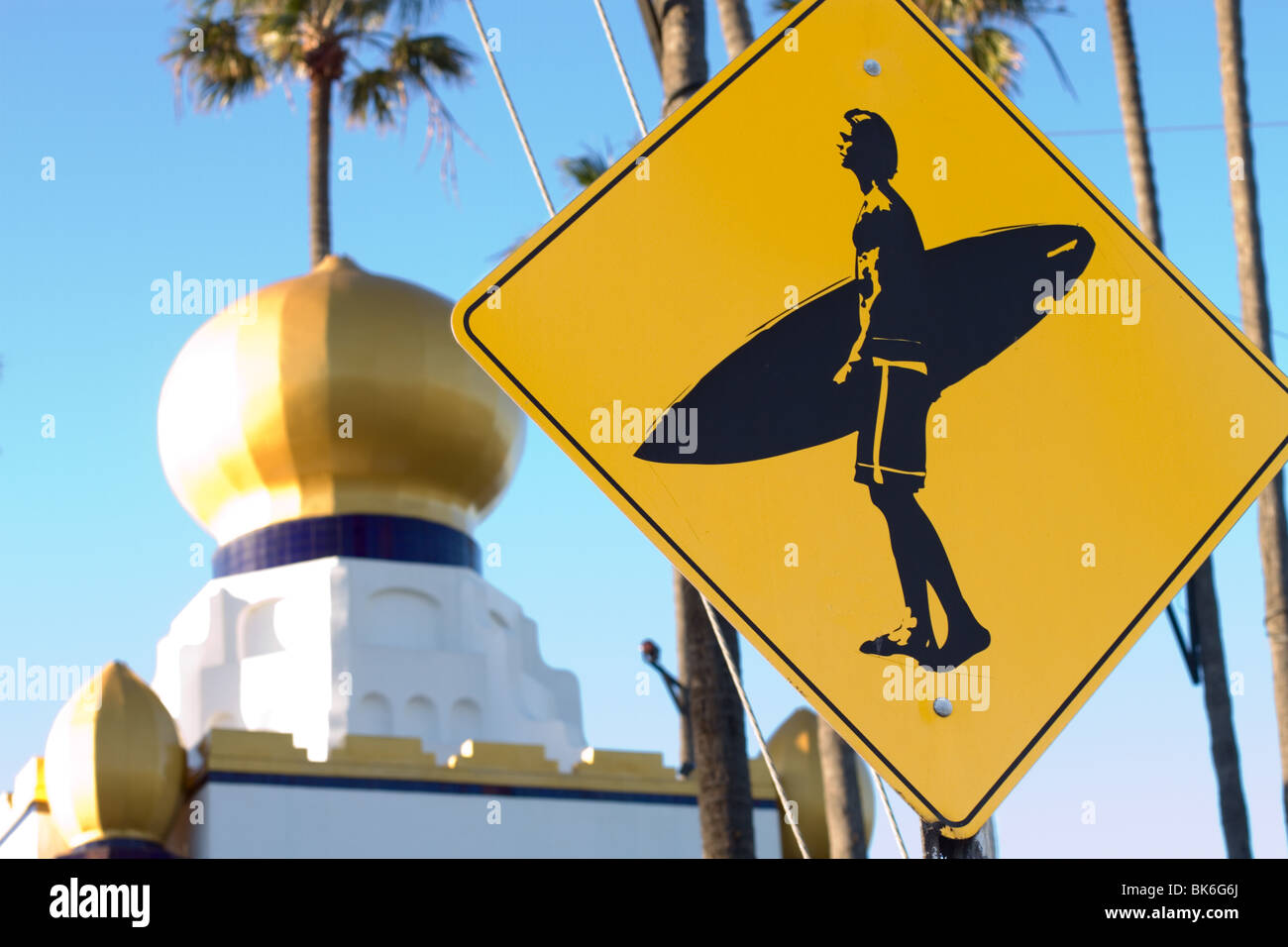 A surfer crossing sign with SRF in the background in Encinitas Stock