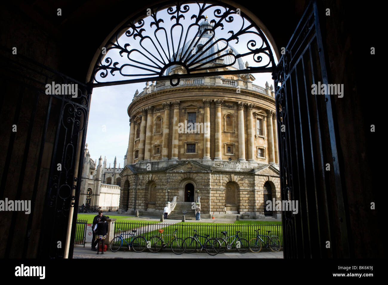 Through Oxford University's Bodleian Library arch, Radcliffe Camera is 150 feet (46 meters) above cobbled Radcliffe Square. Stock Photo