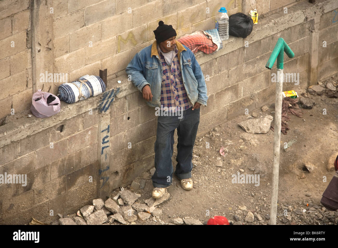 An undocumented Central American migrant traveling across Mexico to work in US waits to jump a cargo train departing Mexico City Stock Photo