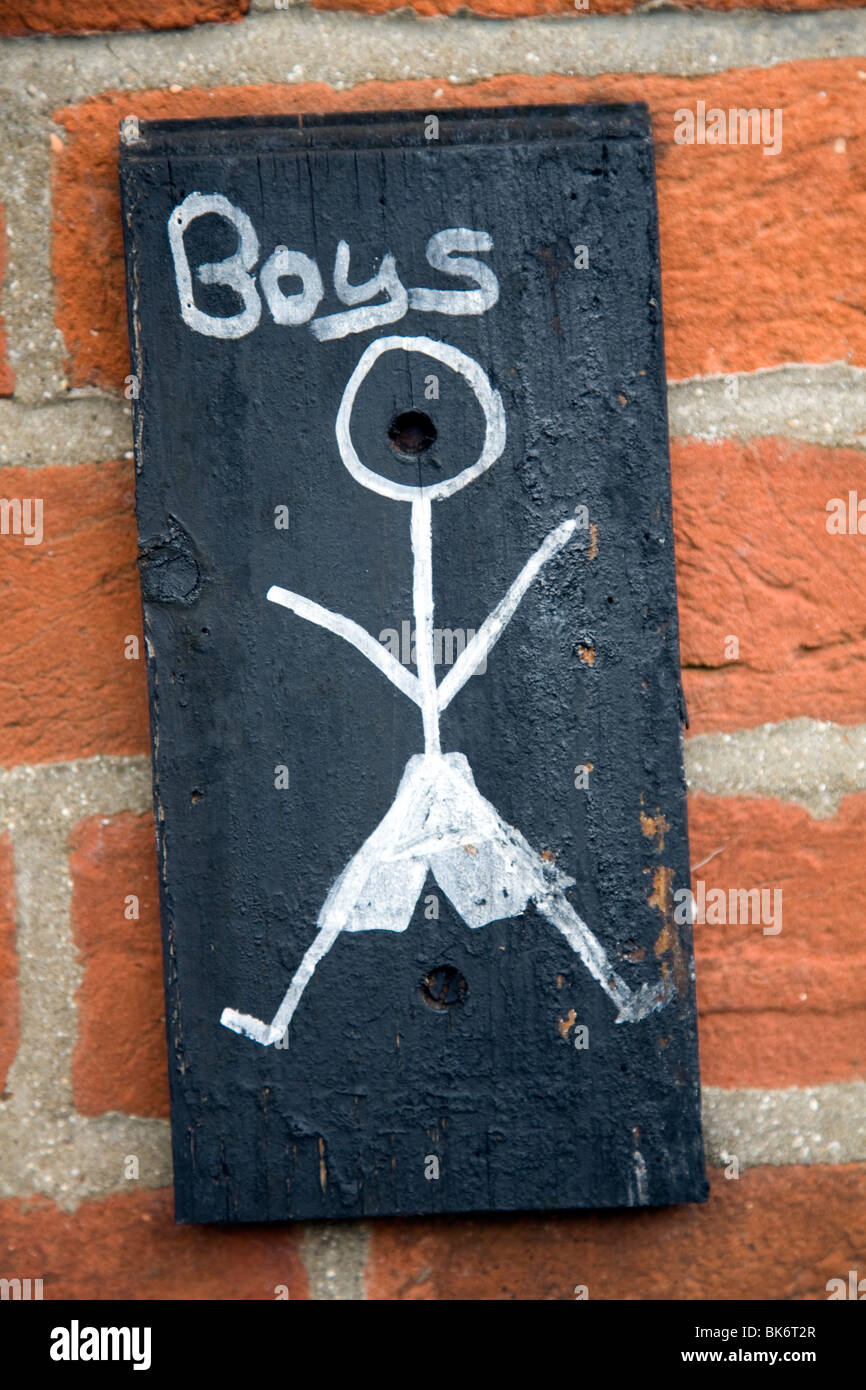 Boys toilet sign on brick wall with stick figure drawing Stock Photo