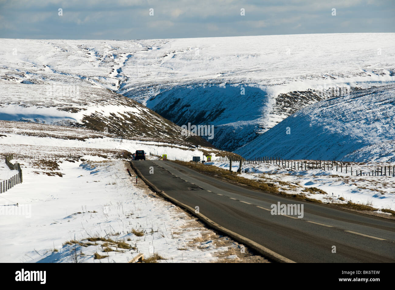 A car on the A57 Snake Pass road in winter, near Glossop, Peak District